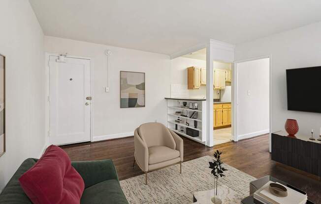A living room with a green couch and a red pillow.