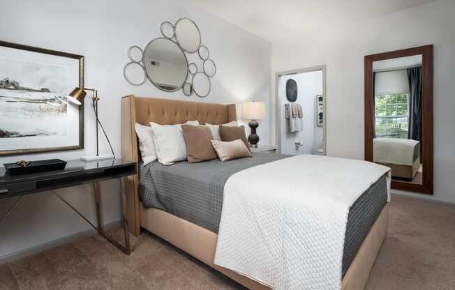 a bedroom with a bed and a desk in a room