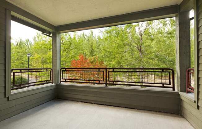 the porch has a view of the woods and a large window