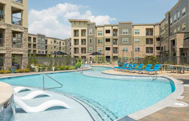 A swimming pool in front of apartment buildings.