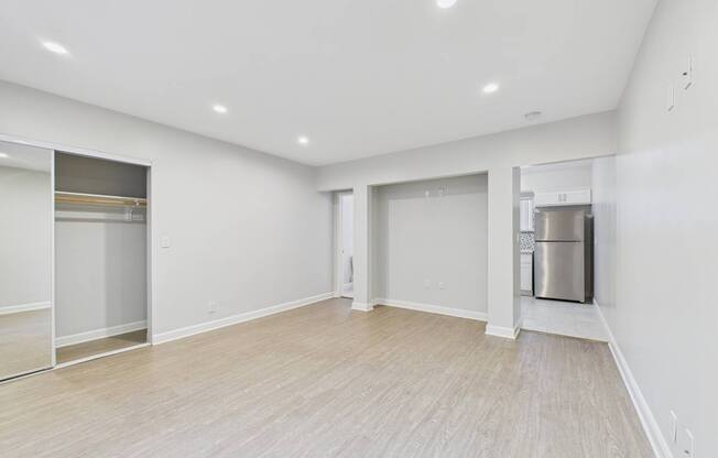 A spacious room with a wooden floor and white walls.