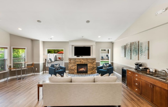 a living room with a couch and chairs and a fireplace