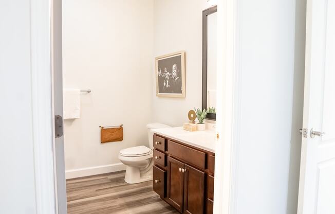 a bathroom with white walls and wood floors