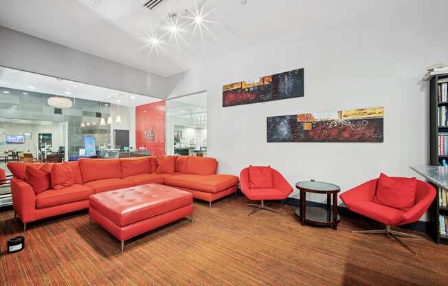 A living room with a red couch and a red chair.