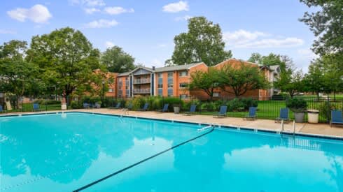 a swimming pool with an apartment building in the background