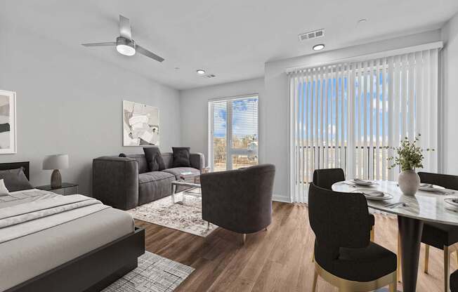 A modern bedroom with a large bed, a dining table with chairs, and a painting on the wall.