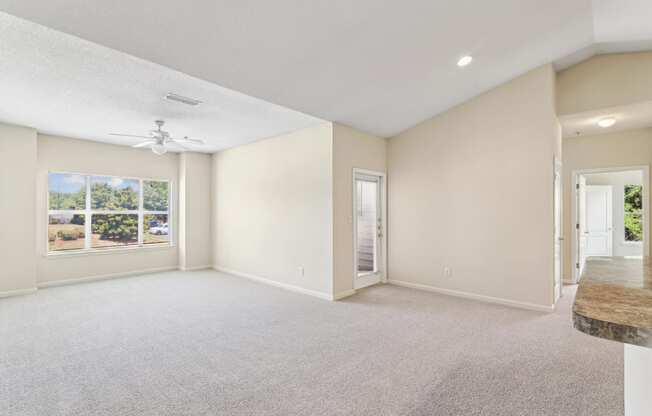 an empty living room with a window and a door