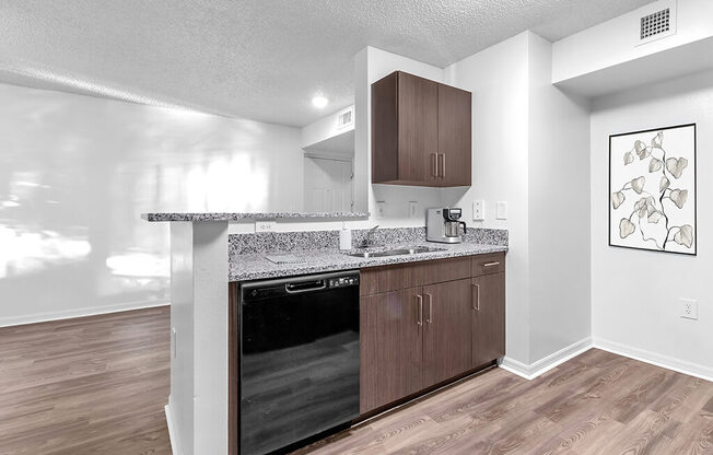 A kitchen with a black oven and brown cabinets.