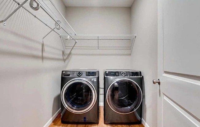 a washer and dryer in a laundry room with a white closet. Circle Pines, MN Lexington Lofts