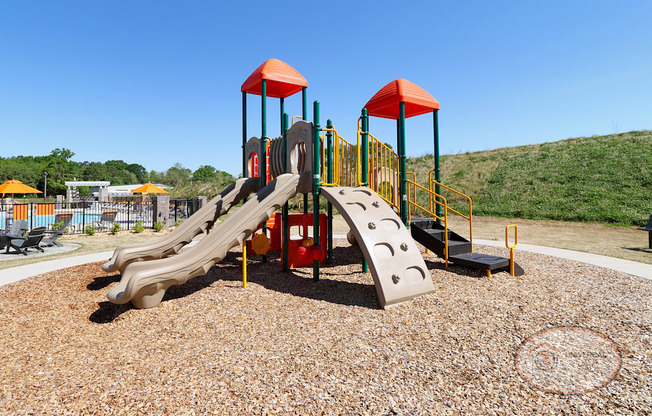 A playground with multi-colored jungle gym and slides.