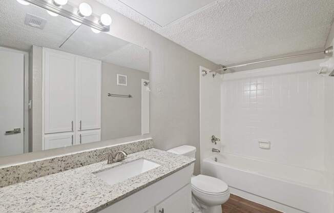 A white bathroom with a sink, toilet, and bathtub.