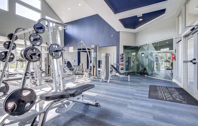 A gym with a variety of equipment including dumbbells and weight machines.