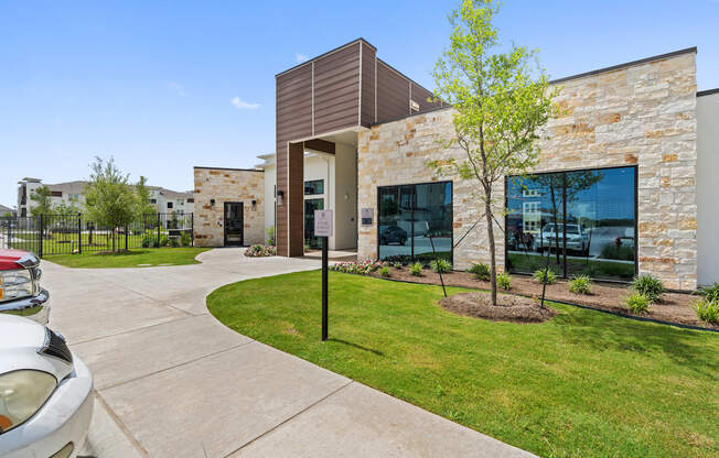 A modern building with a stone facade and a tree in front.