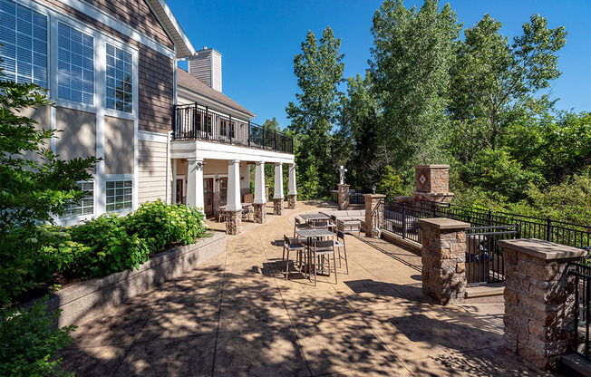 a patio with tables and chairs in front of a building