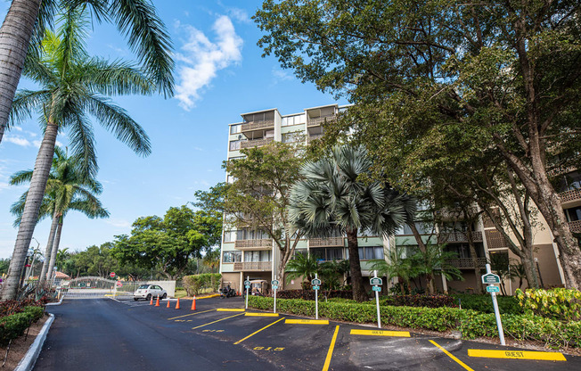 an empty street with palm trees in front of an apartment building at Fairways of Inverrary, Florida