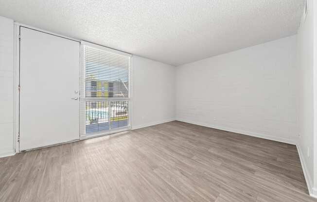 a bedroom with a sliding glass door and hardwood floors