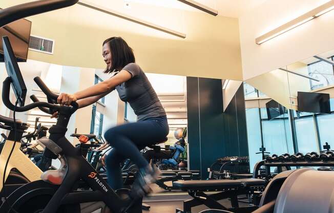 a woman riding an exercise bike in a gym