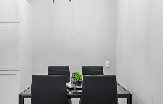 a dining room with a glass table and black chairs