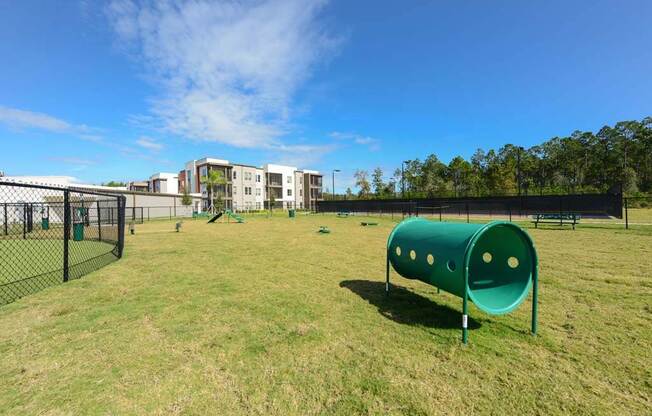a large grassy area with a playground and buildings in the background at Luxor Club, Jacksonville, FL