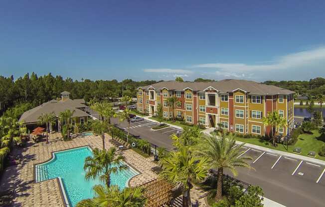 an aerial view of the resort with a pool and palm trees