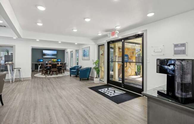 A leasing office with a coffee machine, chairs, and tables at Gwinnett Square Apartments in Duluth, GA
