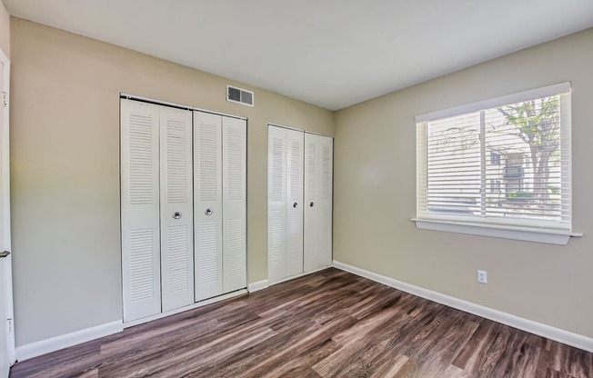 a bedroom with two closets and a window