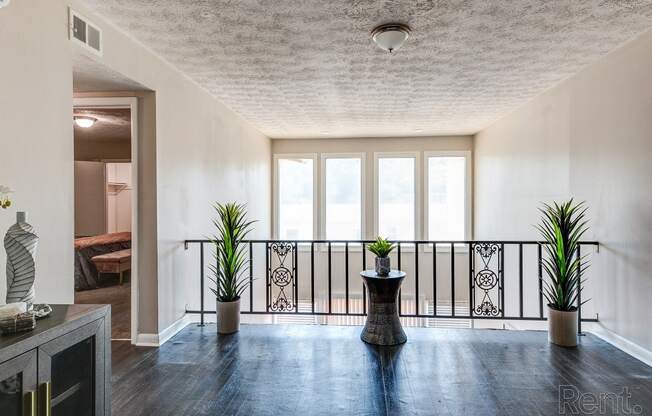 a living room with a balcony and a table with plants