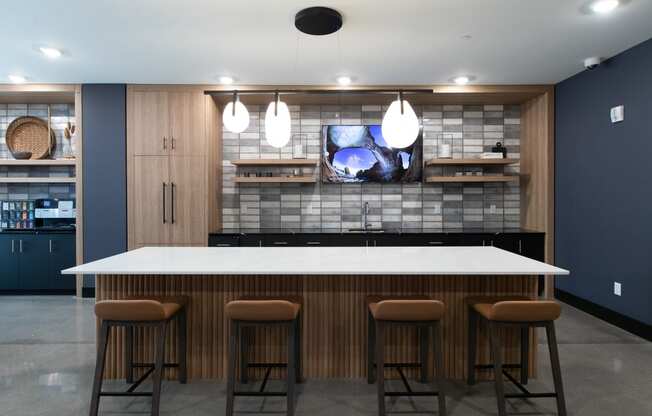 a kitchen with a large island and a tv on the wall