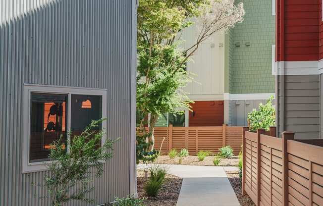 a walkway between two buildings with a fence