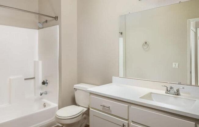A white bathroom with a toilet, sink, and bathtub.