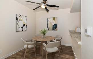 A dining room with a table and chairs.