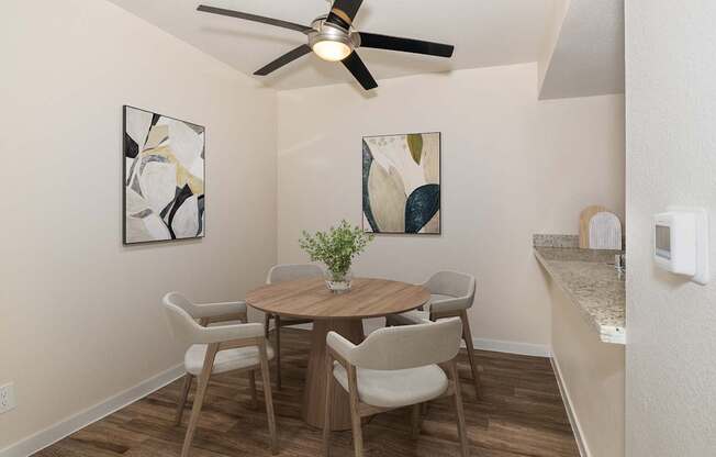 A dining room with a table and chairs.