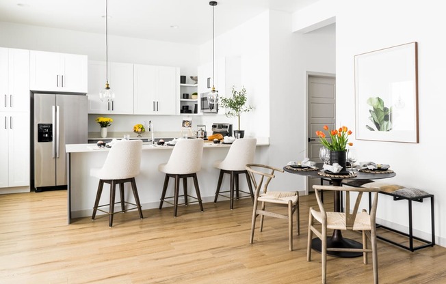 a kitchen and dining area with white cabinets and a table and chairs