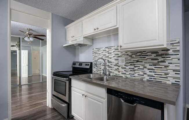 A kitchen with white cabinets and a black stove top oven.