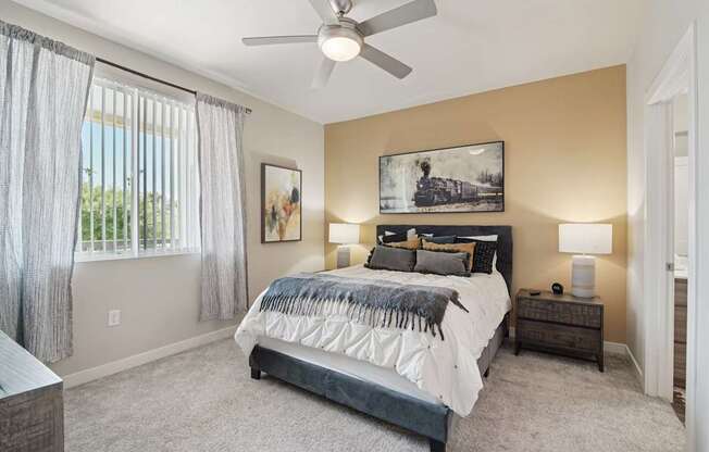 A bedroom with a large bed and a ceiling fan.