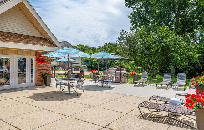 Sun deck patio with tables and chairs under umbrellas at apartment complex