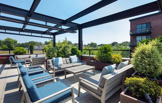 a roof terrace with couches and chairs and plants