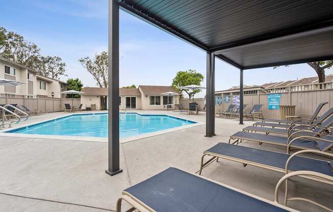 A pool with a blue cover and a metal bench.