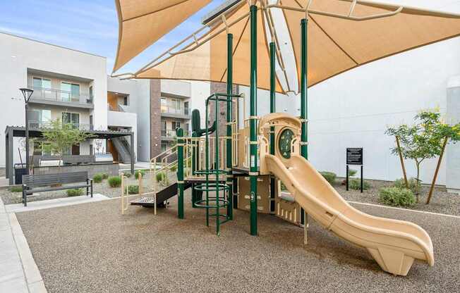 A playground with a slide and a canopy.