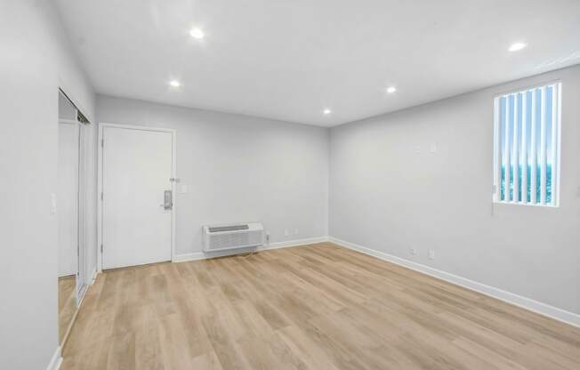 a living room with white walls and a wooden floor
