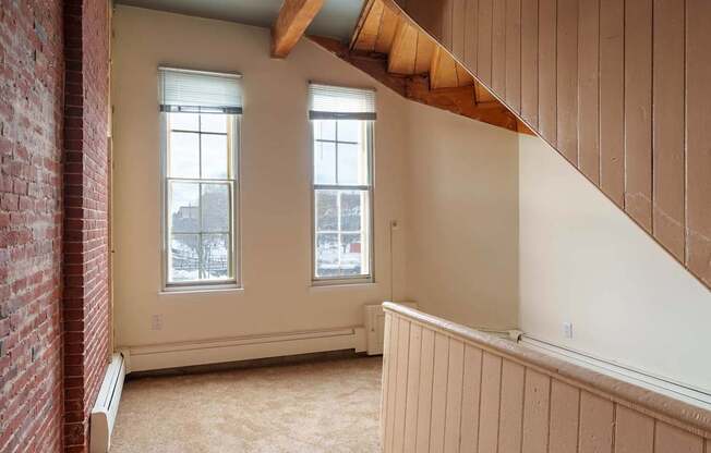 A room with a red brick wall and a wooden beam ceiling.