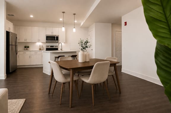 A modern kitchen with a dining table and chairs.