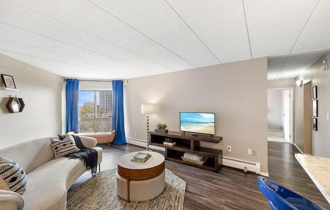 a living room with a couch and a tv at Troy Place Apartments - Troy, MI, Troy, Michigan