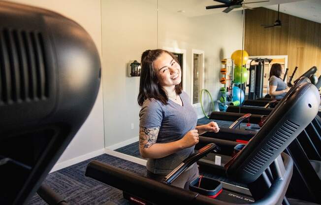 a woman running on a treadmill in a gym