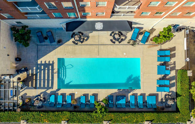 a view of the pool from the top of the hotel with blue umbrellas