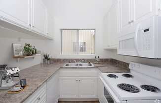 a white kitchen with white appliances and white cabinets