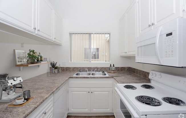 a white kitchen with white appliances and white cabinets