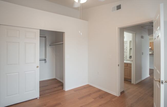 an empty living room with white walls and a wood floor