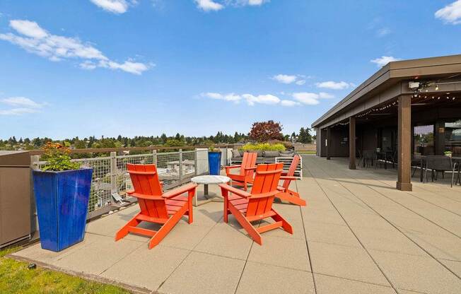 Four orange chairs are arranged on a patio.