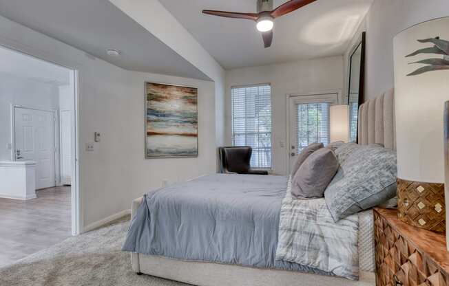 a bedroom with a bed and a ceiling fan
